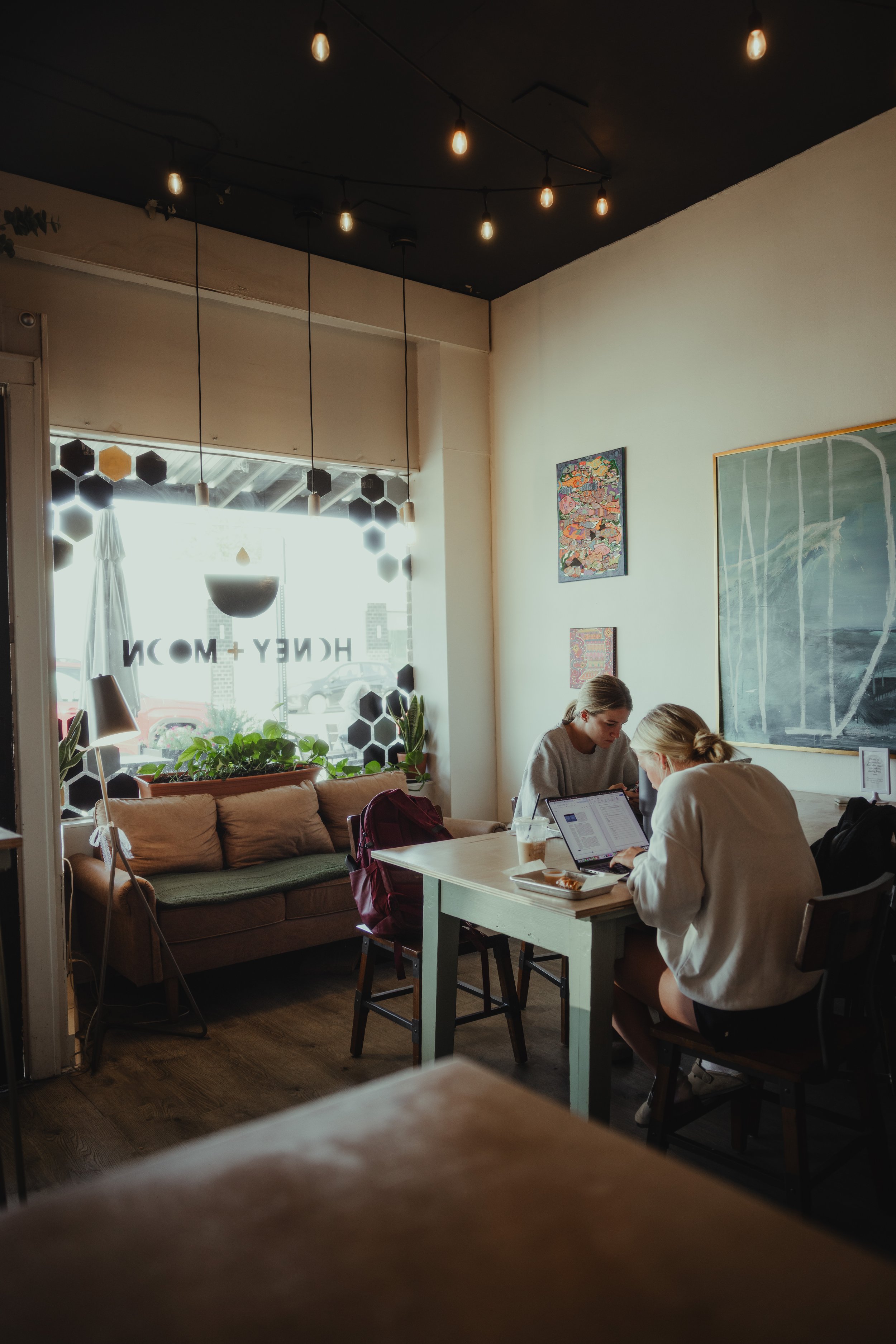 Two guests working together at a table inside a Honey Moon café