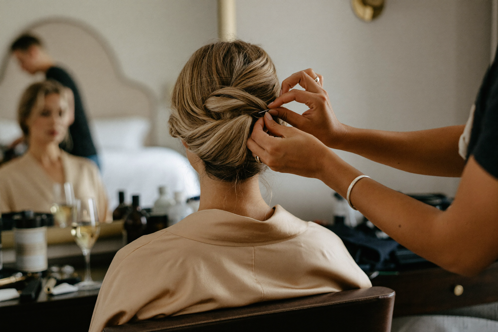 Stylist placing the final pin in a bride's updo