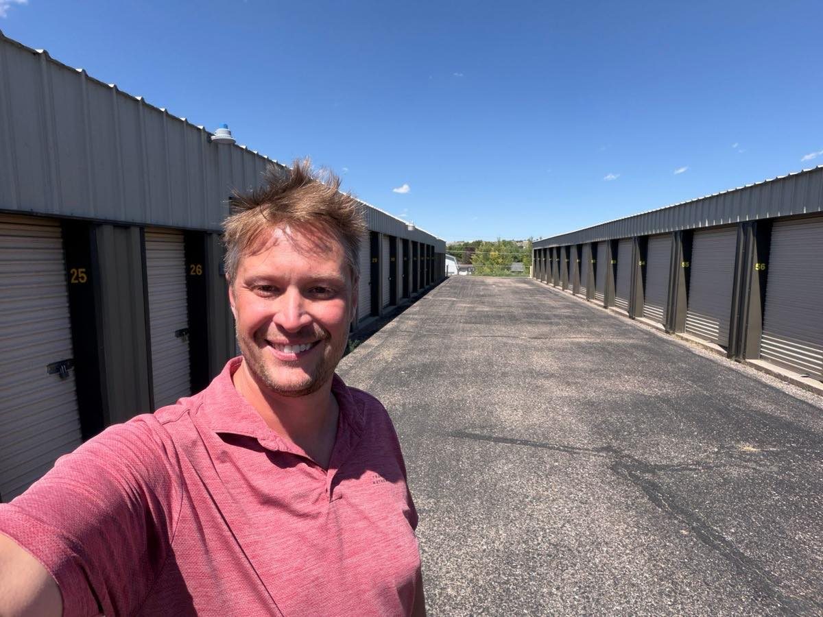 Gabe Strom of We Buy Self Storage walking a drive up self storage facility
